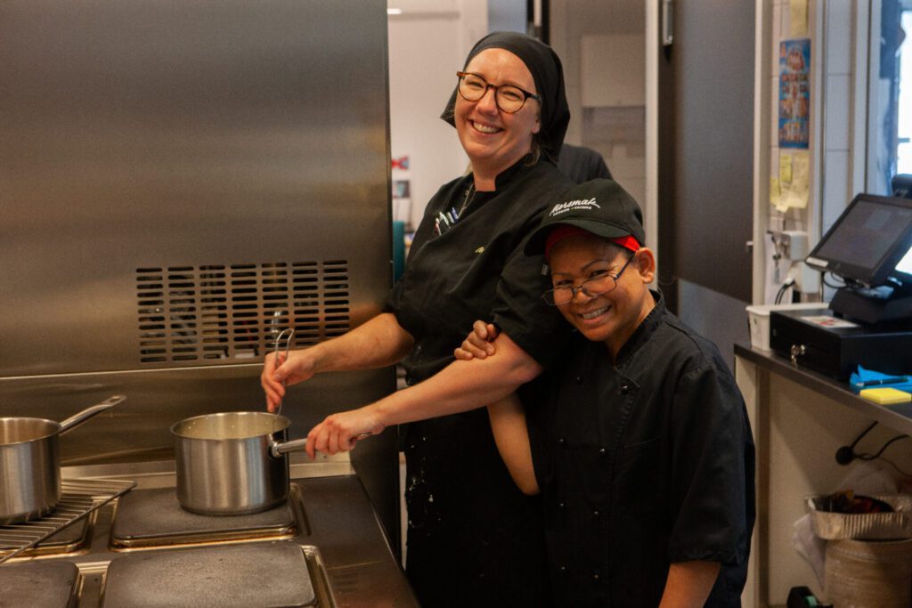 Bilde av to personer på Mersmak som jobber på kjøkkenet